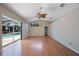 Bright living room with wood floors, ceiling fan, and sliding glass doors to the pool area at 5519 Reflections Blvd, Lutz, FL 33558
