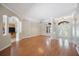 Bright, open-concept living area with hardwood floors, white trim, arched doorways, and natural light at 5519 Reflections Blvd, Lutz, FL 33558
