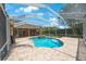Screened-in pool area featuring a uniquely shaped pool, integrated spa, and brick paver patio at 5519 Reflections Blvd, Lutz, FL 33558