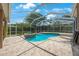 A screened-in pool and spa area with brick pavers is perfect for backyard relaxation and recreation at 5519 Reflections Blvd, Lutz, FL 33558