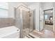 Bathroom with glass enclosed shower, tub, and tile surround at 5620 Night Owl Ter, Palmetto, FL 34221