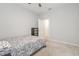 Bedroom features a ceiling fan, neutral walls, and a door to hallway at 5620 Night Owl Ter, Palmetto, FL 34221