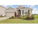 Well-maintained single-story home with a two-car garage, stone accents, and lush landscaping at 5620 Night Owl Ter, Palmetto, FL 34221