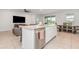 Open kitchen features granite counters, stainless steel appliances, tile flooring, island and adjoining living room at 5620 Night Owl Ter, Palmetto, FL 34221