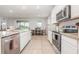Bright kitchen features granite counters, stainless steel appliances, tile flooring, and view to backyard at 5620 Night Owl Ter, Palmetto, FL 34221