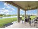 Relaxing covered lanai with outdoor seating overlooking a serene pond and lush green backyard at 5620 Night Owl Ter, Palmetto, FL 34221