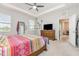 Main bedroom features a tray ceiling, ceiling fan, dresser, and two windows with a view at 5620 Night Owl Ter, Palmetto, FL 34221