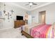 Main bedroom features a tray ceiling, ceiling fan, dresser, and access to other rooms at 5620 Night Owl Ter, Palmetto, FL 34221