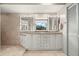 Bathroom with double sinks, granite countertops, and a door to the shower at 5782 Westshore Dr, New Port Richey, FL 34652