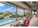 Enclosed lanai with comfortable seating overlooks the beautiful pool and community waterfront at 5782 Westshore Dr, New Port Richey, FL 34652