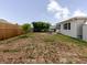 Wide view of the backyard featuring trees, chain-link fence, patio, shed and dining set at 5840 Liddell Dr, New Port Richey, FL 34652