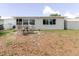 View of backyard patio features outdoor dining area, attached home, and shed at 5840 Liddell Dr, New Port Richey, FL 34652