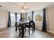 Bright dining area with plenty of natural light, wood-look floors, and stylish floral dining chairs at 5840 Liddell Dr, New Port Richey, FL 34652