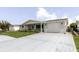 Charming single-story home with a covered porch, long driveway, an attached garage, and neat landscaping at 5840 Liddell Dr, New Port Richey, FL 34652