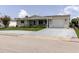 Attractive single-story home with a covered front porch, a long driveway, and an attached garage at 5840 Liddell Dr, New Port Richey, FL 34652