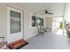 Relaxing front porch with ceiling fan, seating, and welcoming entrance to the home at 5840 Liddell Dr, New Port Richey, FL 34652