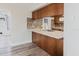 Kitchen includes tile backsplash, stainless sink, wood cabinets, and open floor plan at 5840 Liddell Dr, New Port Richey, FL 34652