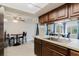 Kitchen showcases wood cabinetry, backsplash, stainless steel sink and fixtures, and natural light at 5840 Liddell Dr, New Port Richey, FL 34652