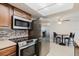 Bright kitchen features stainless steel appliances, tile backsplash, breakfast nook and wood cabinets at 5840 Liddell Dr, New Port Richey, FL 34652