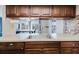 Kitchen showcases wood cabinetry, backsplash, stainless steel sink and fixtures, and natural light at 5840 Liddell Dr, New Port Richey, FL 34652