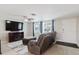 Bright living room featuring a ceiling fan, neutral walls, wood-look tile floors, and a cozy seating area at 5840 Liddell Dr, New Port Richey, FL 34652