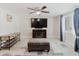 Inviting living room featuring a ceiling fan, entertainment center, neutral walls, and a bright window at 5840 Liddell Dr, New Port Richey, FL 34652