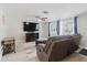Comfortable living room with a ceiling fan, large windows, and wood-look tile flooring at 5840 Liddell Dr, New Port Richey, FL 34652