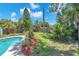 Landscaped backyard featuring a sparkling in-ground pool surrounded by lush tropical plants and a wooden fence at 5927 10Th N St, St Petersburg, FL 33703
