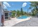 Landscaped backyard featuring a refreshing pool with a pink flamingo floatie, surrounded by a stone paver patio at 5927 10Th N St, St Petersburg, FL 33703