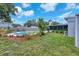 A refreshing pool is surrounded by grass and mulch-covered planting beds and a privacy fence at 5927 10Th N St, St Petersburg, FL 33703