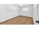 This bedroom features a ceiling fan and two windows with wood-look flooring at 5927 10Th N St, St Petersburg, FL 33703