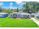 Charming single-story home with a well-manicured lawn, a covered porch, and a neatly paved driveway at 5927 10Th N St, St Petersburg, FL 33703