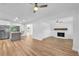 Bright, open living room featuring hardwood floors, a stone fireplace, and modern ceiling fans at 5927 10Th N St, St Petersburg, FL 33703