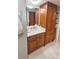 Bathroom featuring wooden cabinetry, a large mirror and marble floors at 6424 Thicket Trl, New Port Richey, FL 34653