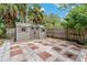 View of the backyard shed with wood panelling, window shutters, and a beautiful tile patio at 6625 Interbay Blvd, Tampa, FL 33611