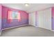 Bright bedroom featuring neutral carpeting, two closets, and whimsical wallpaper at 6625 Interbay Blvd, Tampa, FL 33611