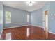 Bright bedroom with laminate flooring, two windows, and neutral paint at 6625 Interbay Blvd, Tampa, FL 33611