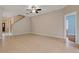 Bright living room with staircase features tile flooring, neutral paint, and access to other rooms at 6625 Interbay Blvd, Tampa, FL 33611