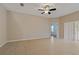 Spacious living room features tile flooring, neutral paint, a ceiling fan, and sliding glass doors at 6625 Interbay Blvd, Tampa, FL 33611
