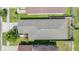 A bird's-eye view shows the home's roof and backyard within a vibrant, green neighborhood setting at 7414 Indigo Oasis Ct, Gibsonton, FL 33534