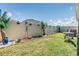 A well-maintained lawn features an outdoor dining set and a privacy fence with garden boxes at 7414 Indigo Oasis Ct, Gibsonton, FL 33534