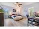 Comfortable bedroom features a ceiling fan, light colored wood flooring, and a window at 7414 Indigo Oasis Ct, Gibsonton, FL 33534