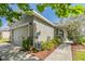 Landscaped front exterior with flowering bushes and a 'home sweet home' sign at 7414 Indigo Oasis Ct, Gibsonton, FL 33534