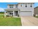 Charming two-story home with a well-maintained lawn and a welcoming front porch at 7641 Sail Clover Ln, Zephyrhills, FL 33540