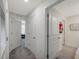 Bright hallway has several closed doors; the floor is carpet and ceramic tile at 7641 Sail Clover Ln, Zephyrhills, FL 33540
