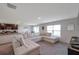 Spacious living room with a large sectional sofa, open to the dining and kitchen areas at 7641 Sail Clover Ln, Zephyrhills, FL 33540