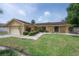 Charming single-story home with a well-manicured lawn and lush landscaping featuring a sprinkler system at 7902 Heather Ct, Tampa, FL 33634