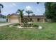 Charming single-story home with a well-manicured lawn, palm trees, and a two-car garage at 7902 Heather Ct, Tampa, FL 33634