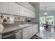 Kitchen featuring stainless steel appliances, white cabinets, and a view into the eat-in kitchen at 7902 Heather Ct, Tampa, FL 33634