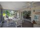 Enclosed patio featuring table, chairs, ceiling fan and adjacent sunroom at 7902 Heather Ct, Tampa, FL 33634